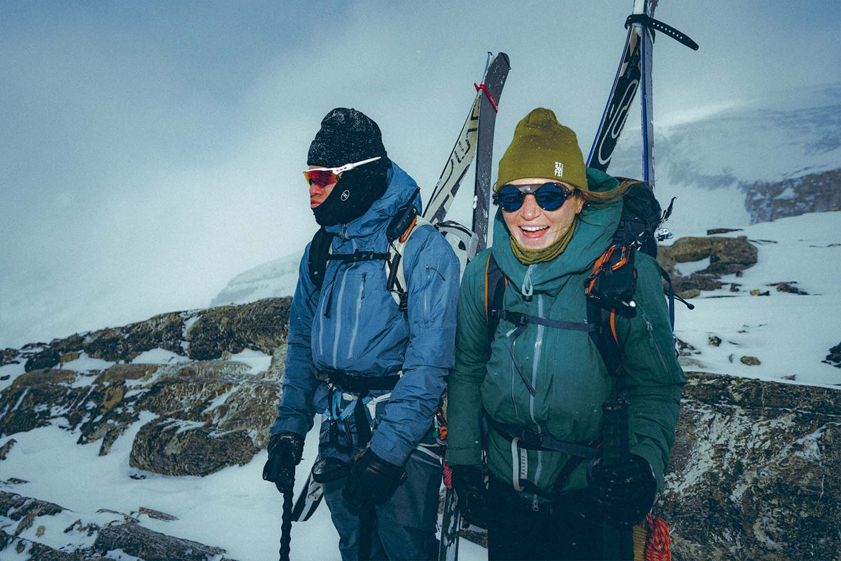 Two ski tourers in STRATUS beanies on a windswept ridge
