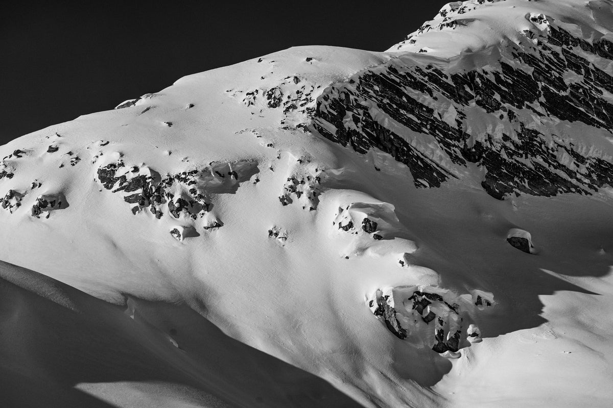 A snow-covered mountain face in black and white
