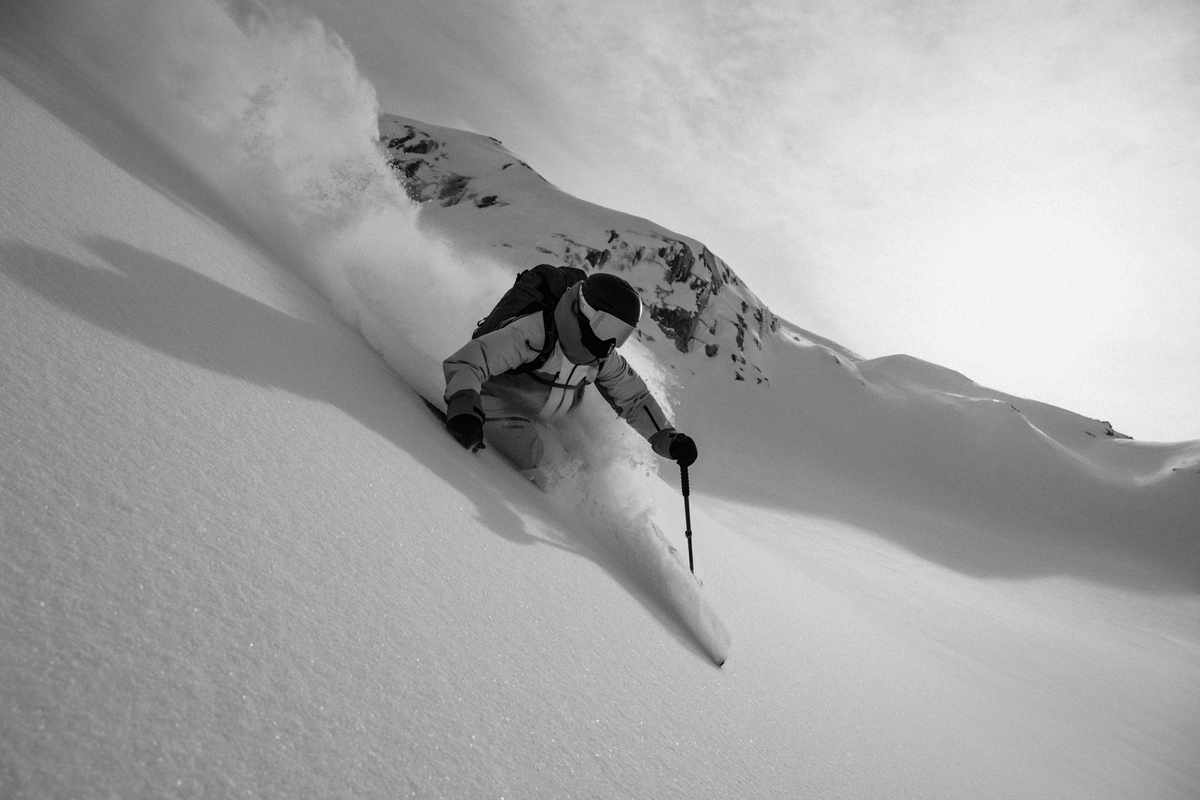 A skier turning through deep powder, in black and white